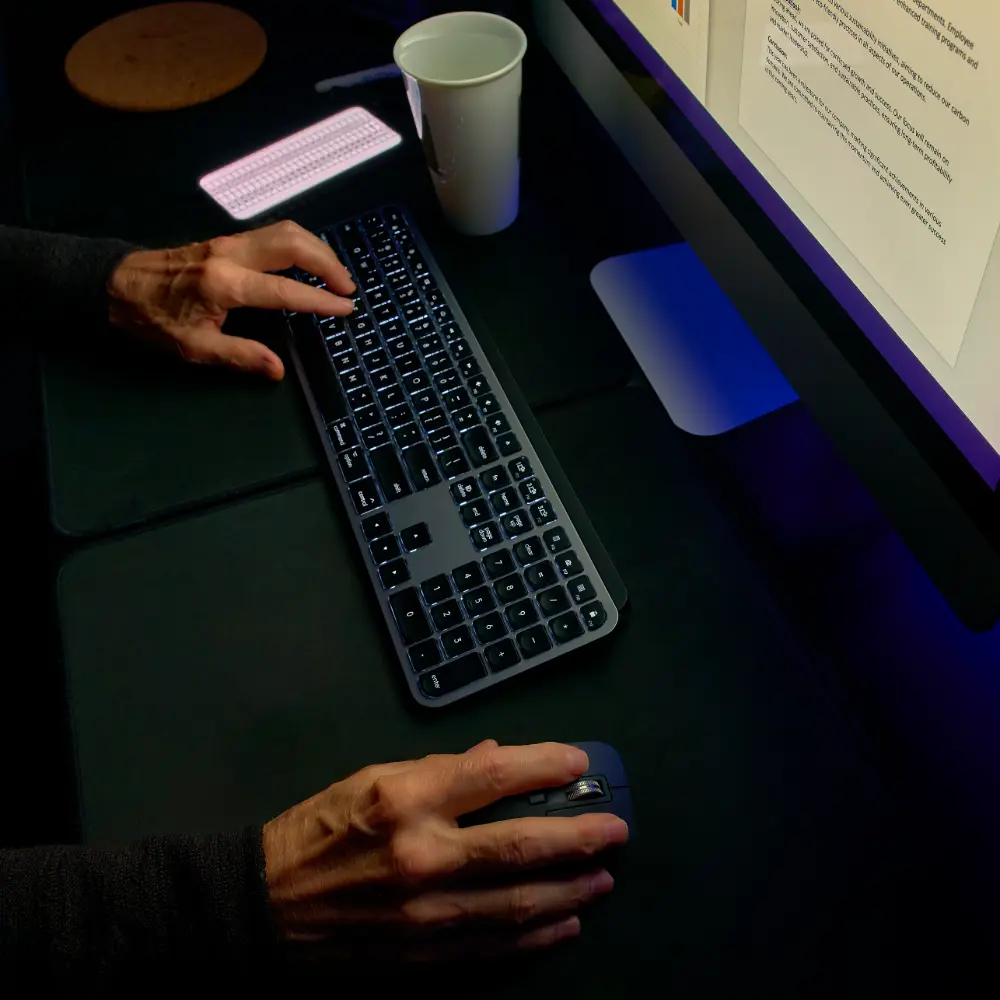 hands-using-computer-devices-on-a-dark-desktop-2026-03-18-09-38-41-utc